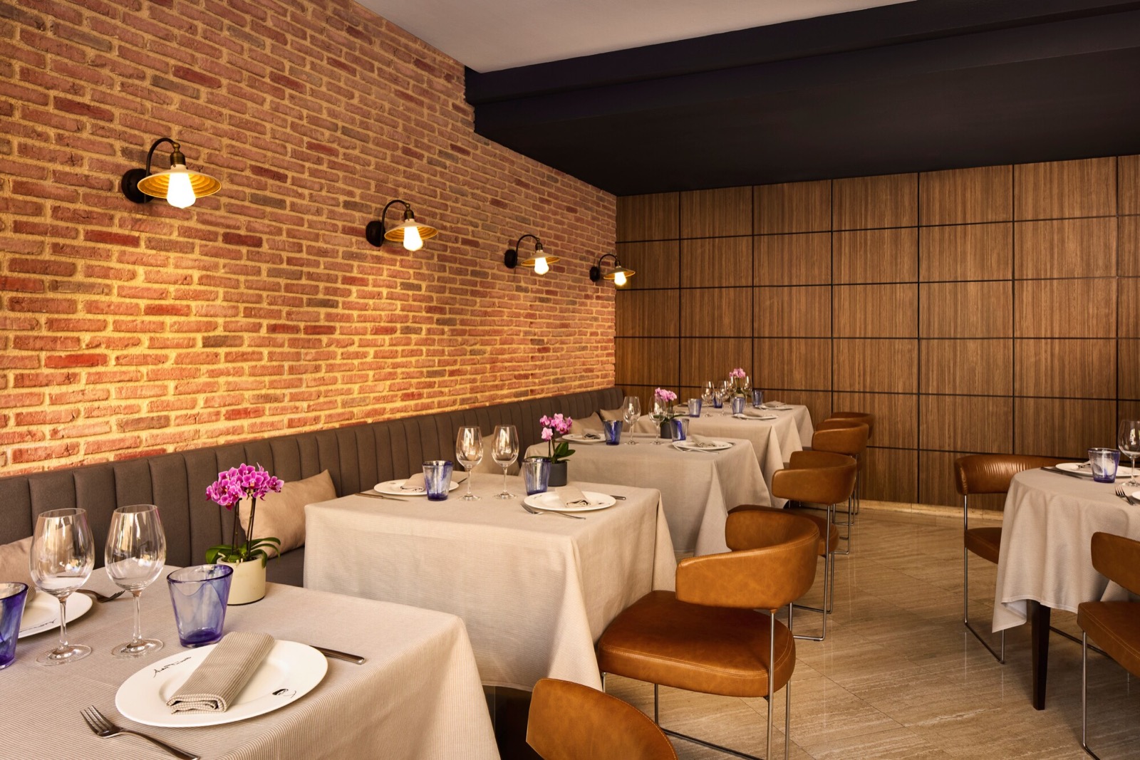 Don Giovanni restaurant with an exposed brick wall, lit at night