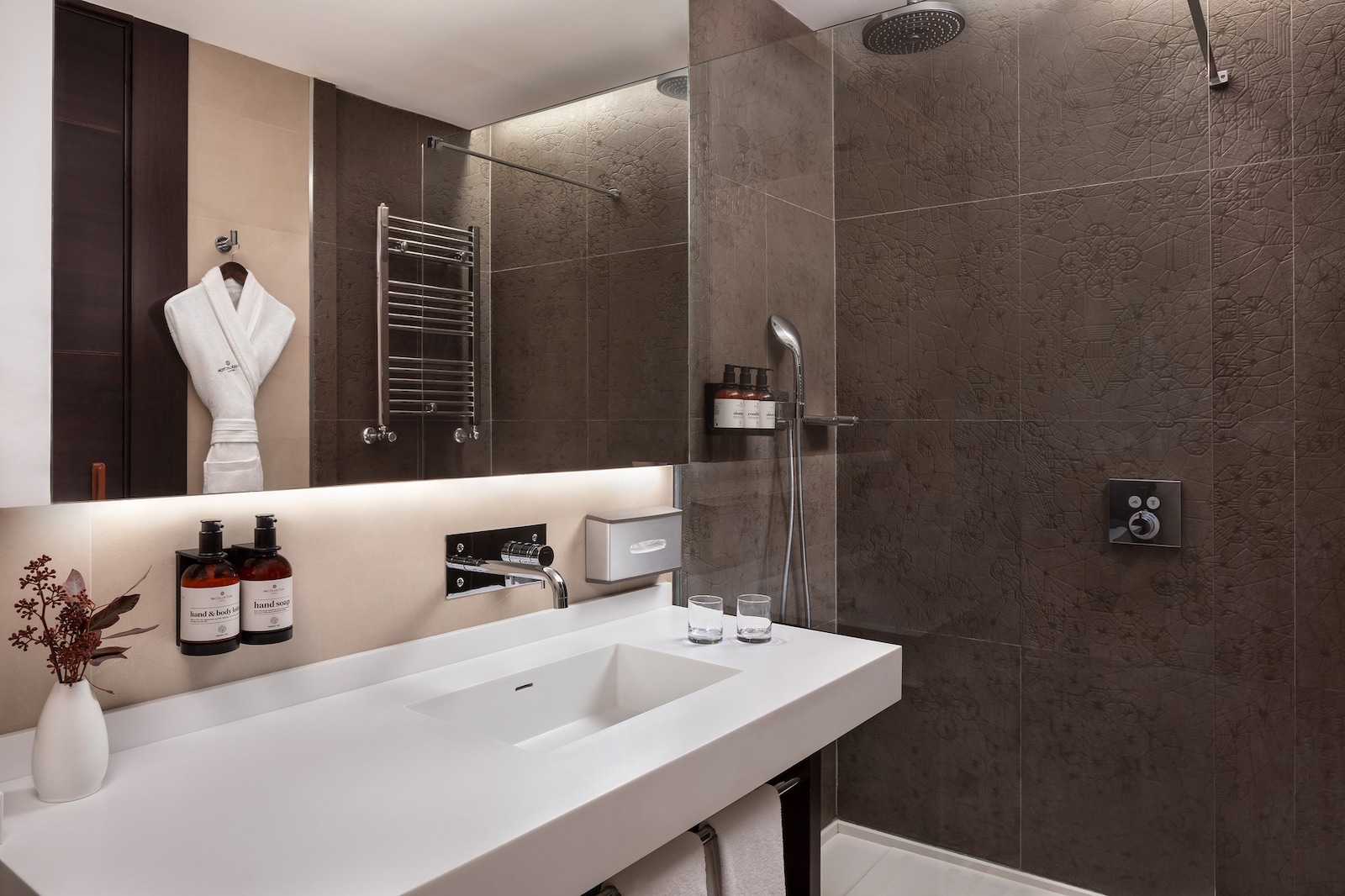 Superior room bathroom with a rainfall shower and marble-look tiling