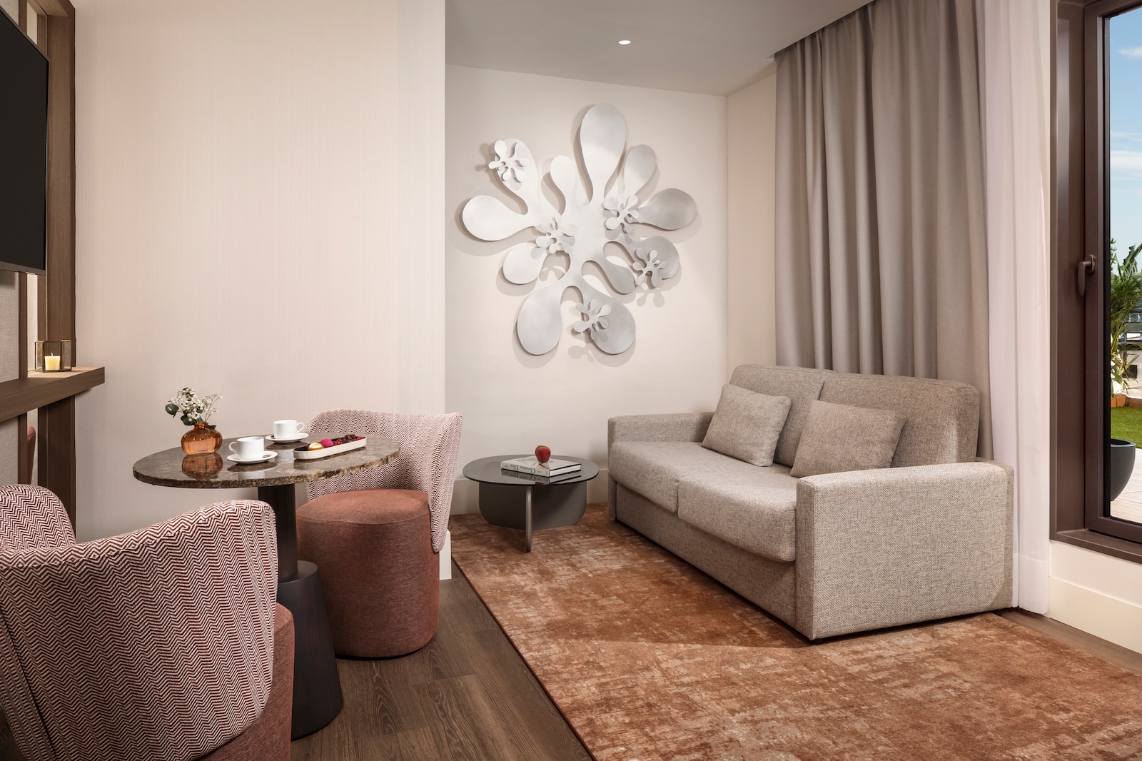 Suite living area with a grey sofa and wall art