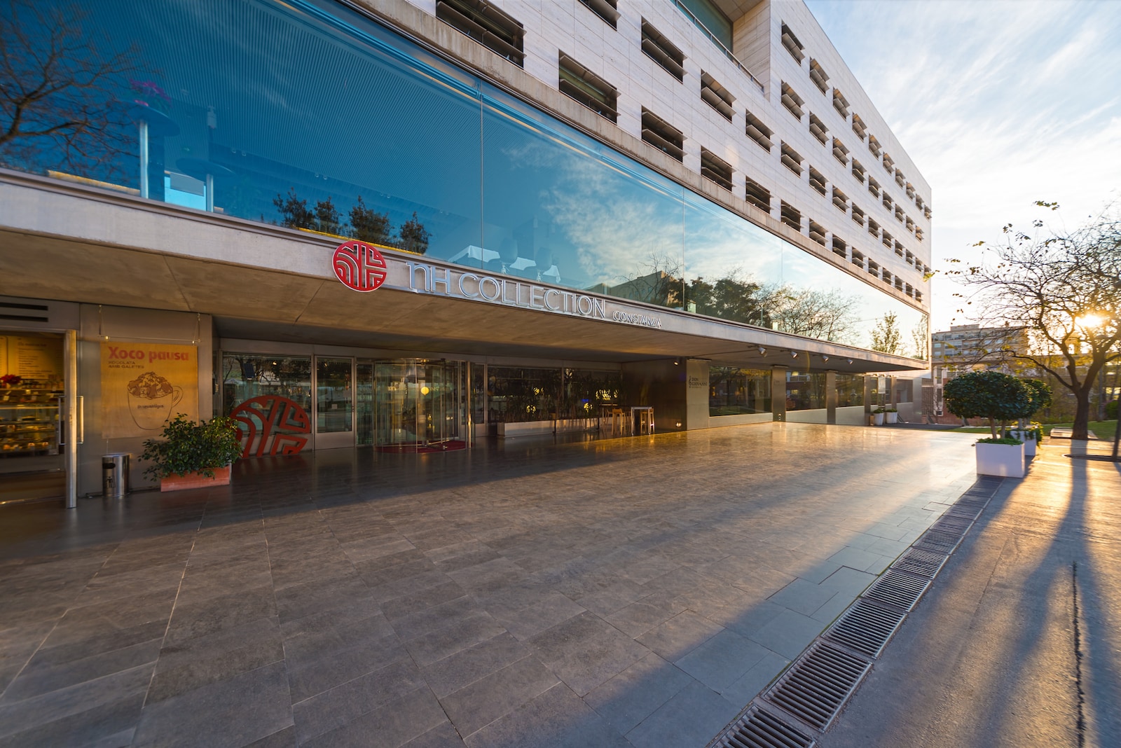 NH Collection Constanza building entrance at sunset with logo signage