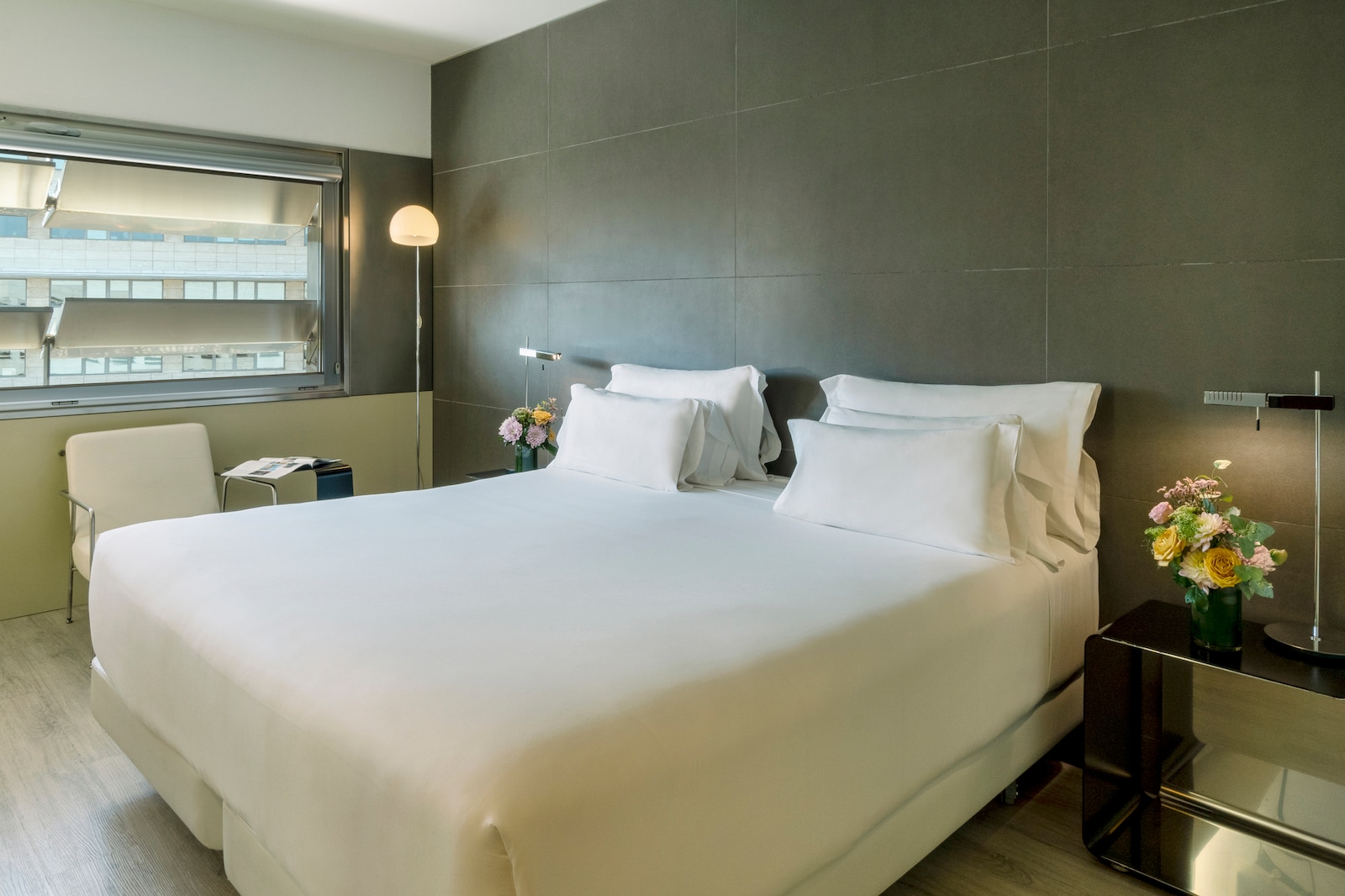 Premium room bed against a dark tiled headboard wall with a city view