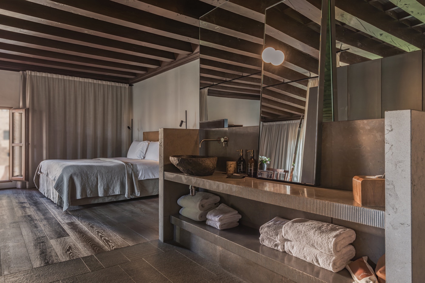 Can Oliver Suite bedroom with wood beamed ceiling and stone walls