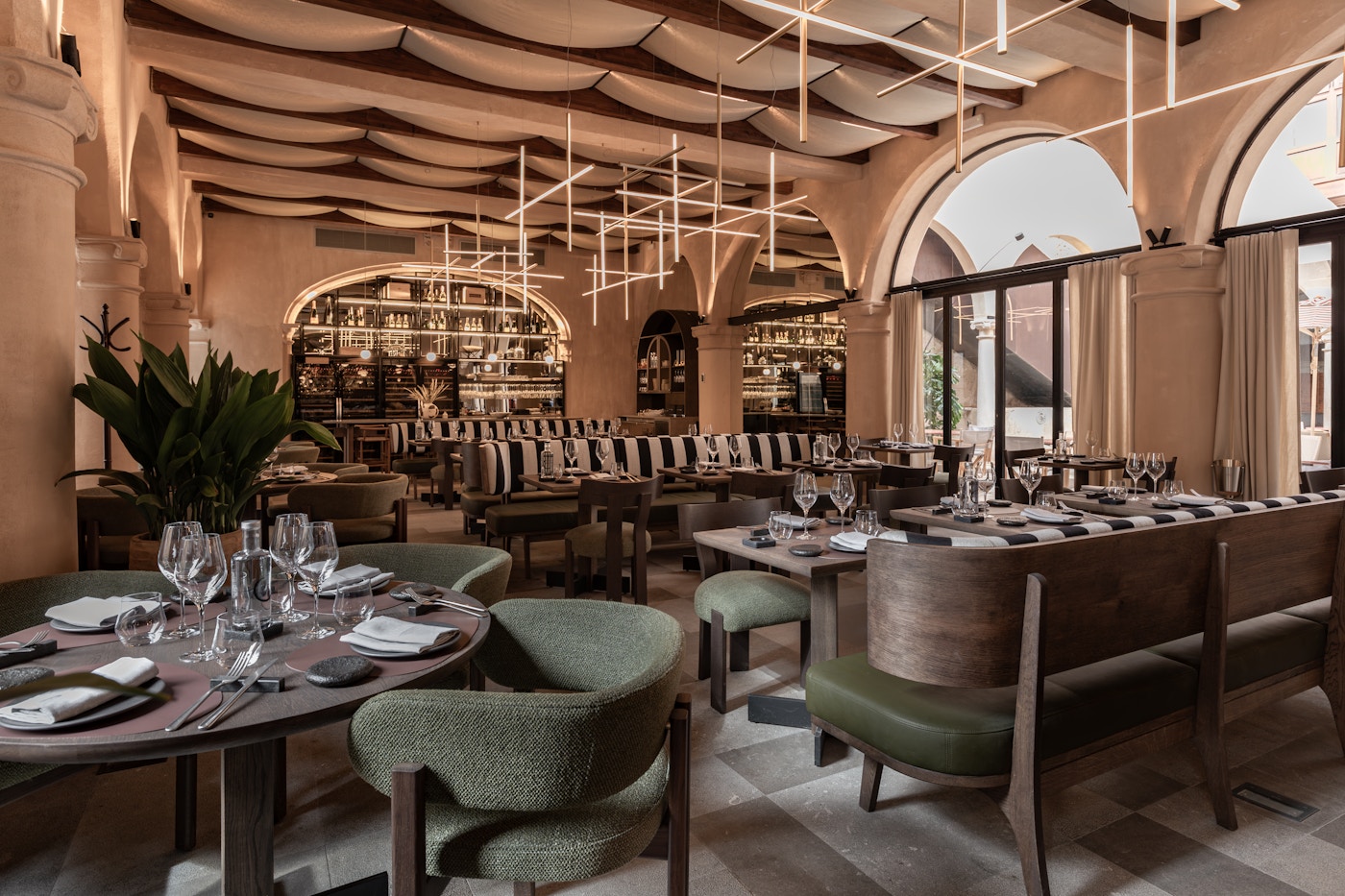NOI restaurant dining room with arched windows and green upholstered chairs
