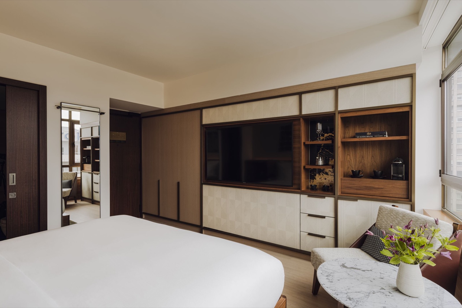 Deluxe room with wall-length wood cabinetry and a mirror reflecting the closet