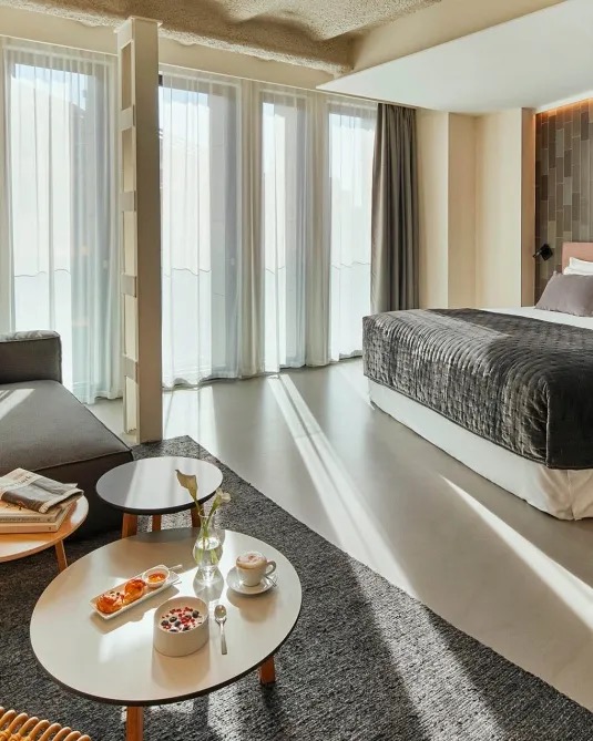 Ohla Eixample junior suite with a sitting area and floor-to-ceiling windows