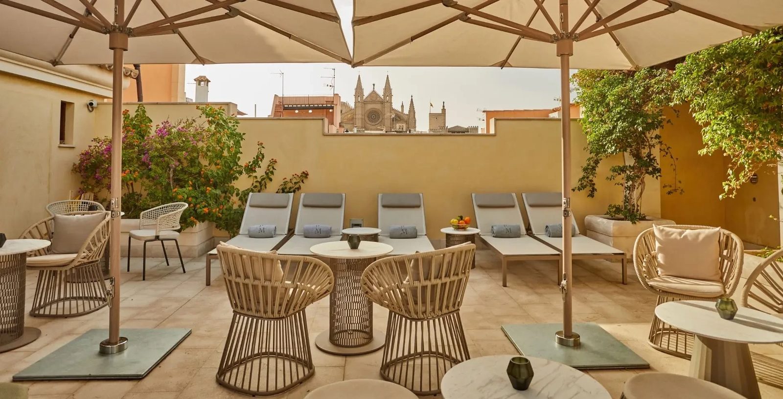 Rooftop terrace with sun loungers, umbrellas and Palma Cathedral in the distance