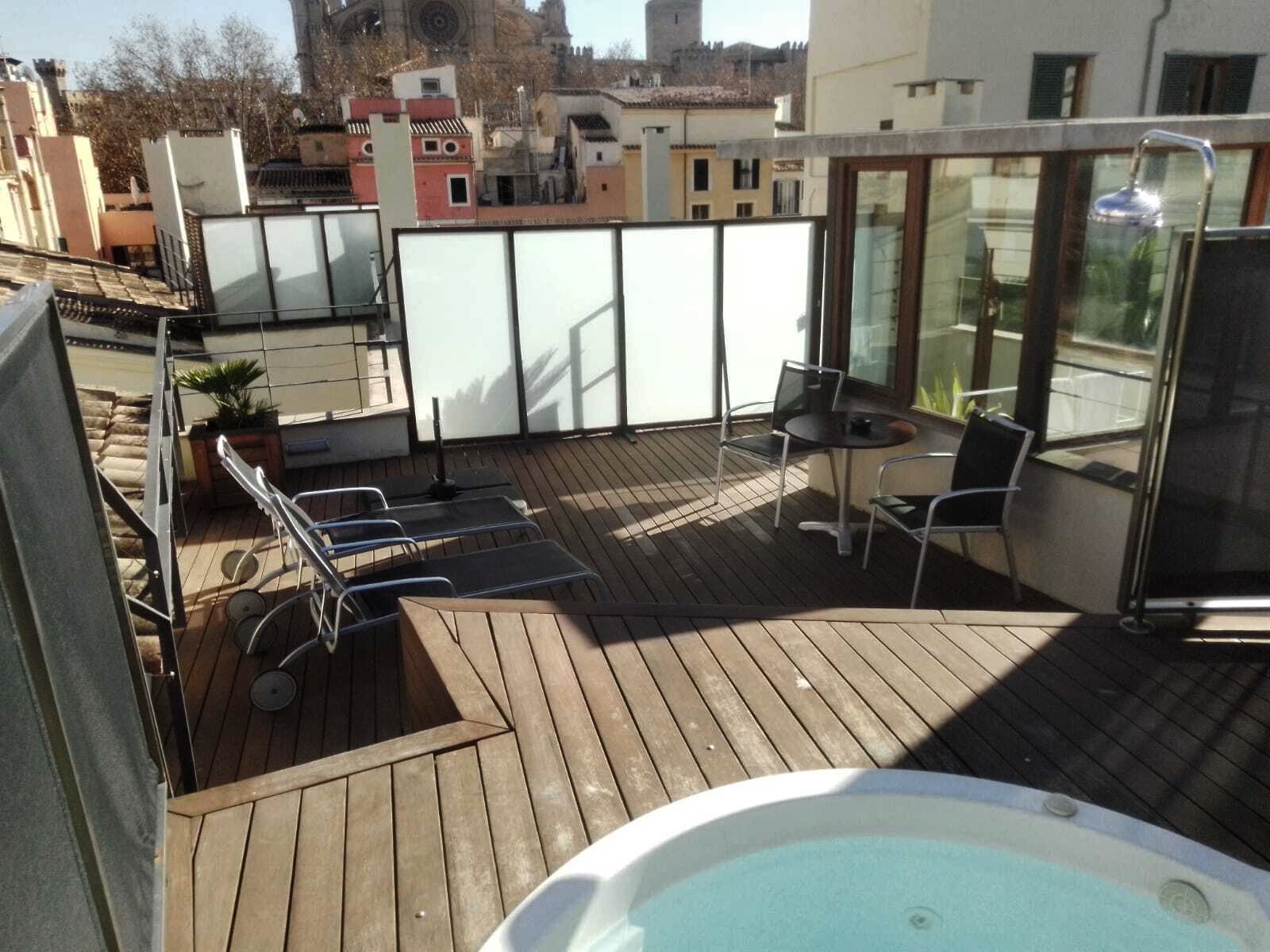 Rooftop terrace with a private hot tub, sun loungers and a view over La Lonja's rooftops to Palma Cathedral