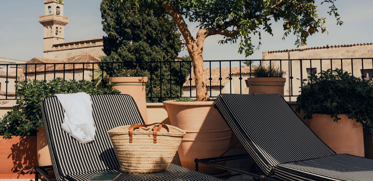 Rooftop terrace sun loungers with the old town bell tower in view
