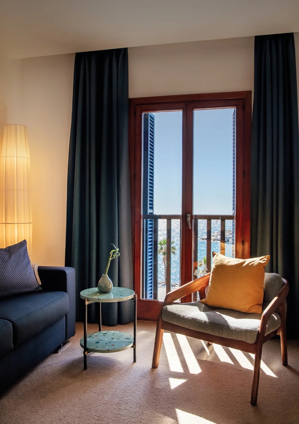 Port House Suite living area with a sofa and armchair beside a window looking straight out to the sea