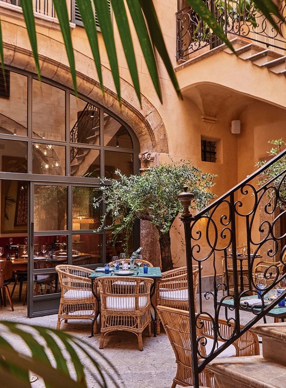 Courtyard terrace dining area at Puro Grand Hotel with wrought iron staircase