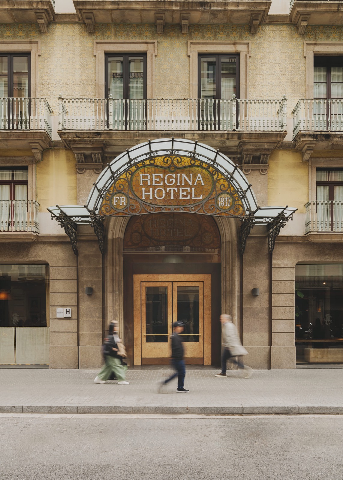 Hotel Regina entrance with a wrought-iron canopy and 1917 signage