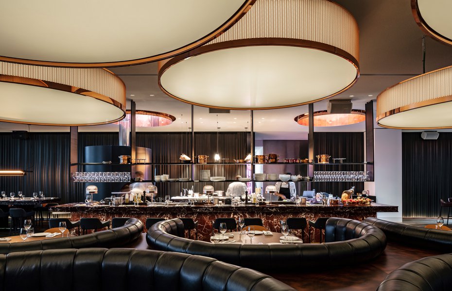 Mr Porter restaurant with round pendant lights and curved leather booths