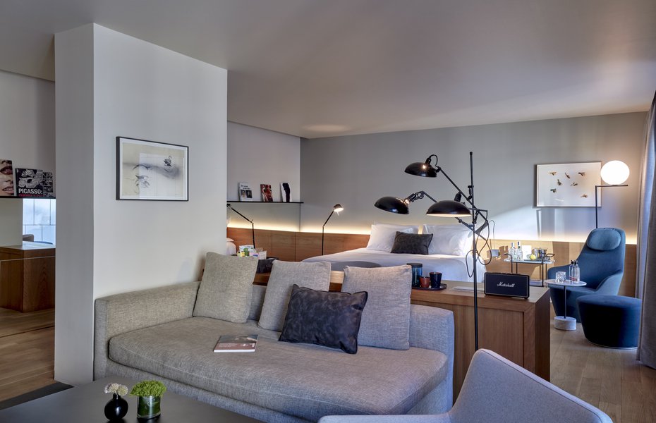 Suite living area with a grey sofa, framed art and floor lamps