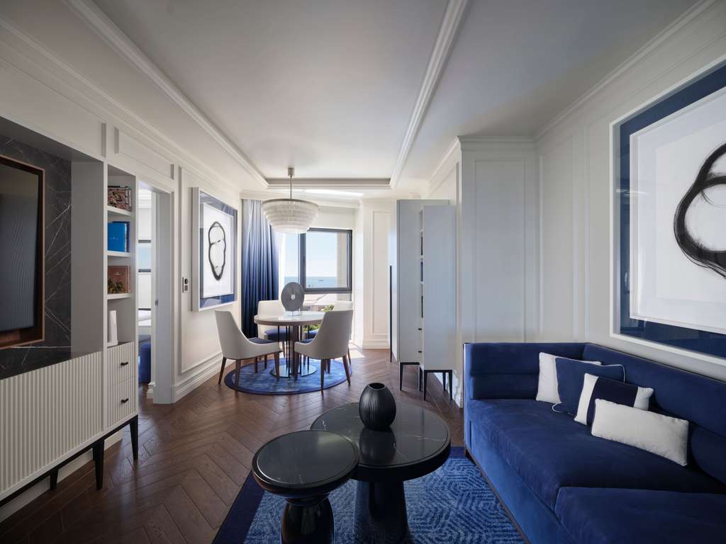 Suite living and dining area with a navy sofa and a sea view
