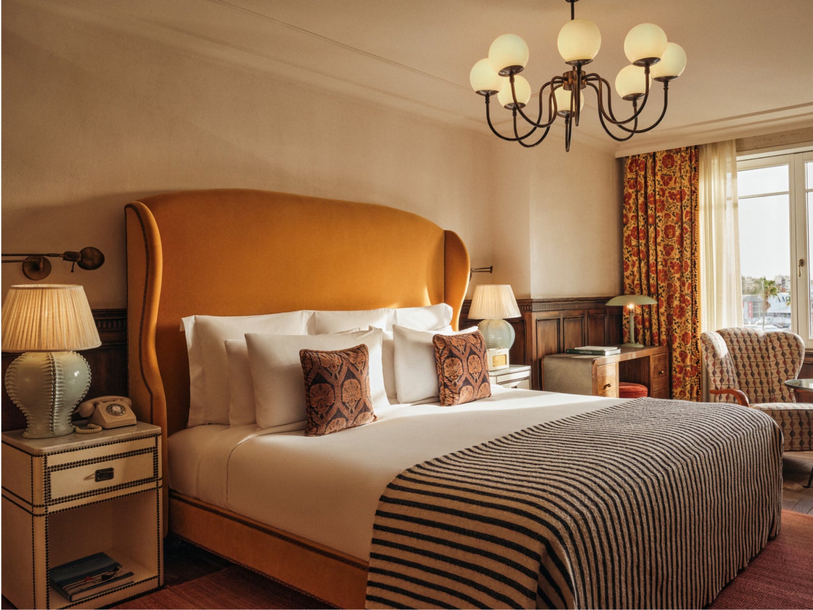 Bedroom with a mustard wingback headboard and floral curtains