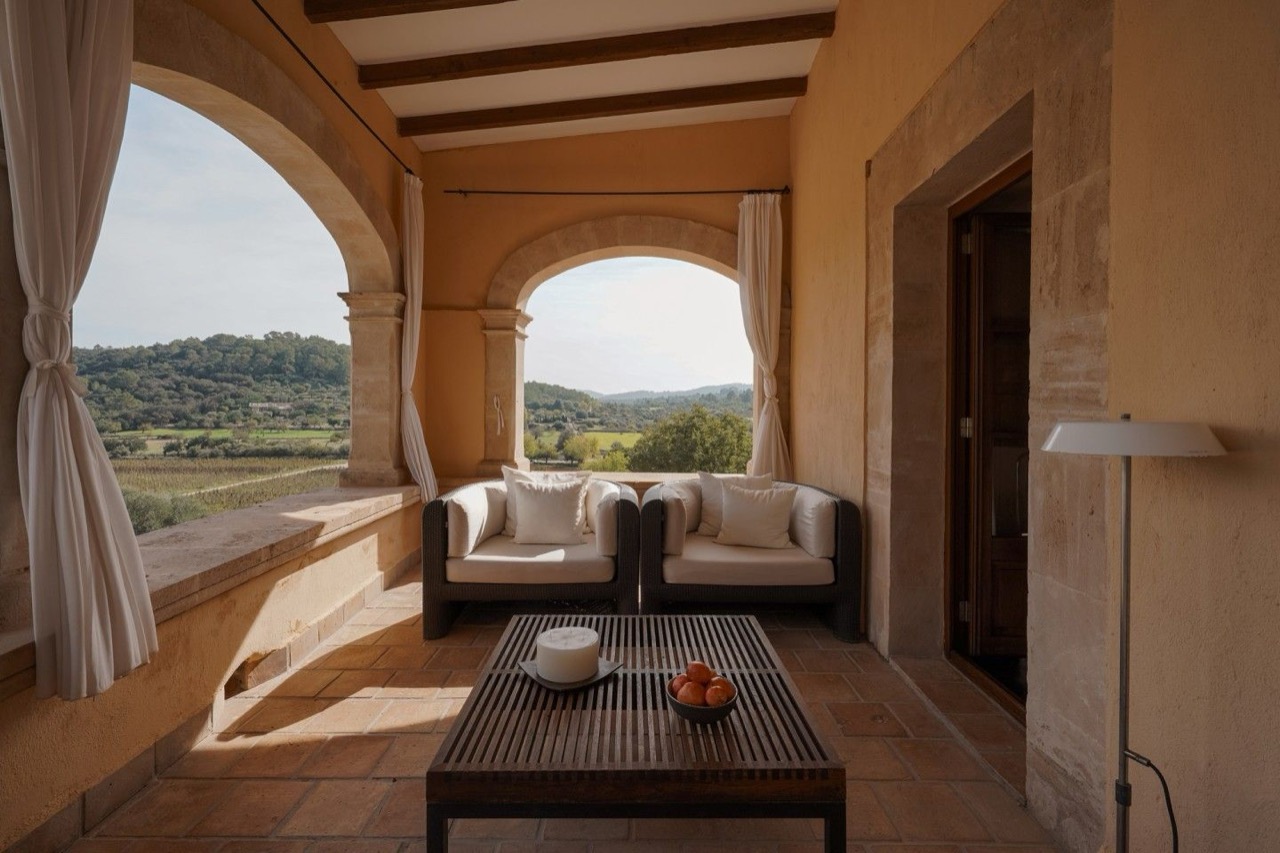 Arched stone terrace at Son Brull with seating overlooking the vineyard and surrounding hills