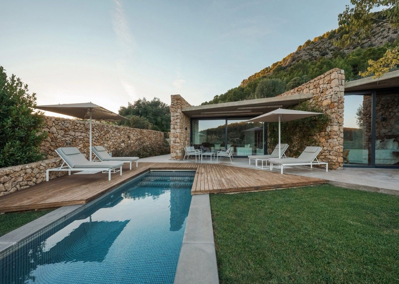 Stone walled private pool and terrace at one of Son Brull's suites, with loungers and countryside views