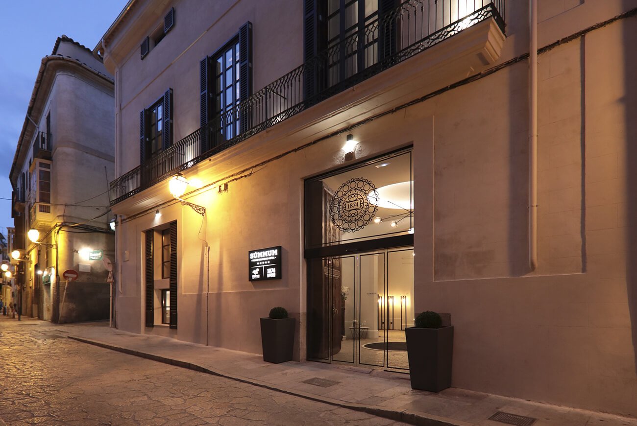 Hotel entrance and stone facade on a cobbled street at dusk