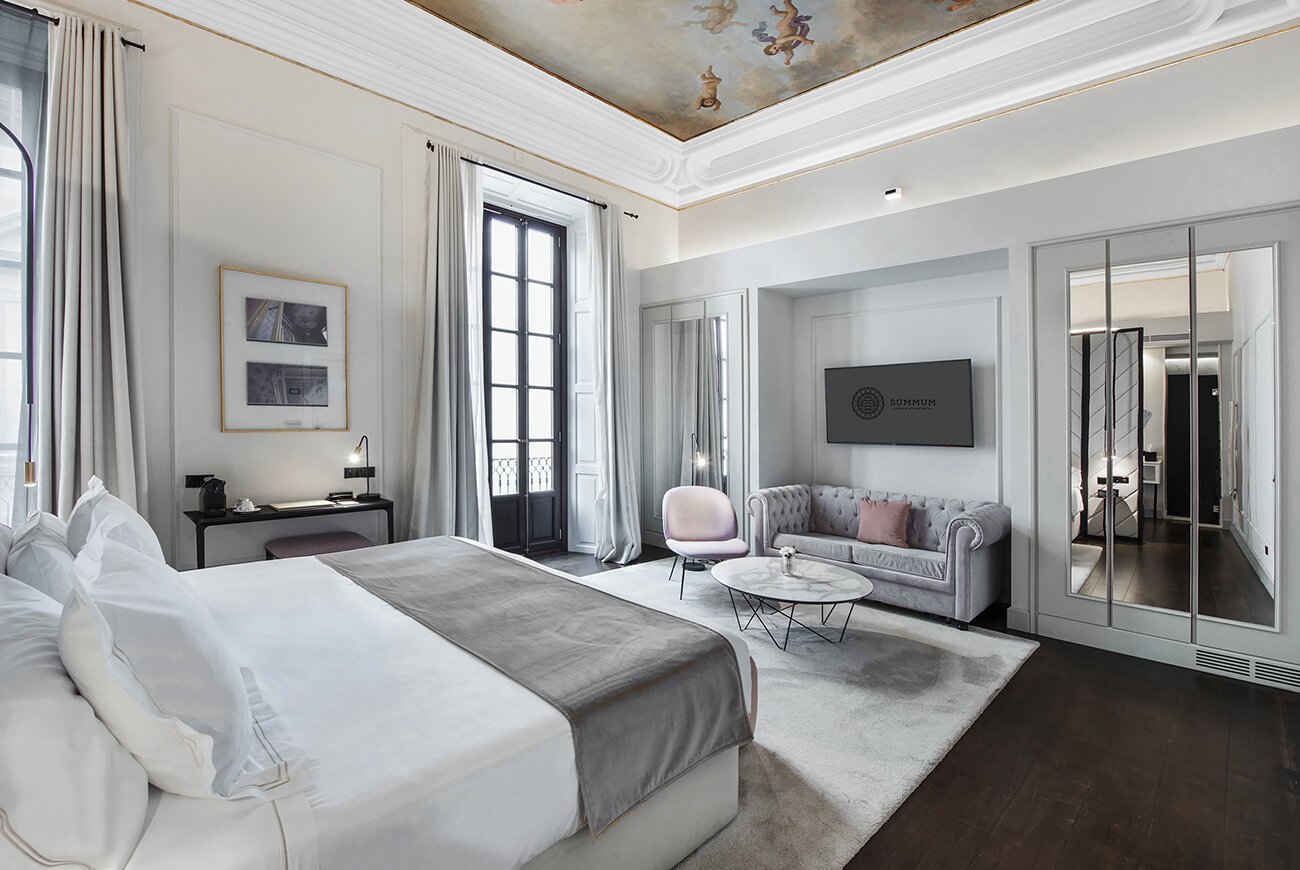 Bedroom with a painted ceiling fresco, tall windows and a seating area