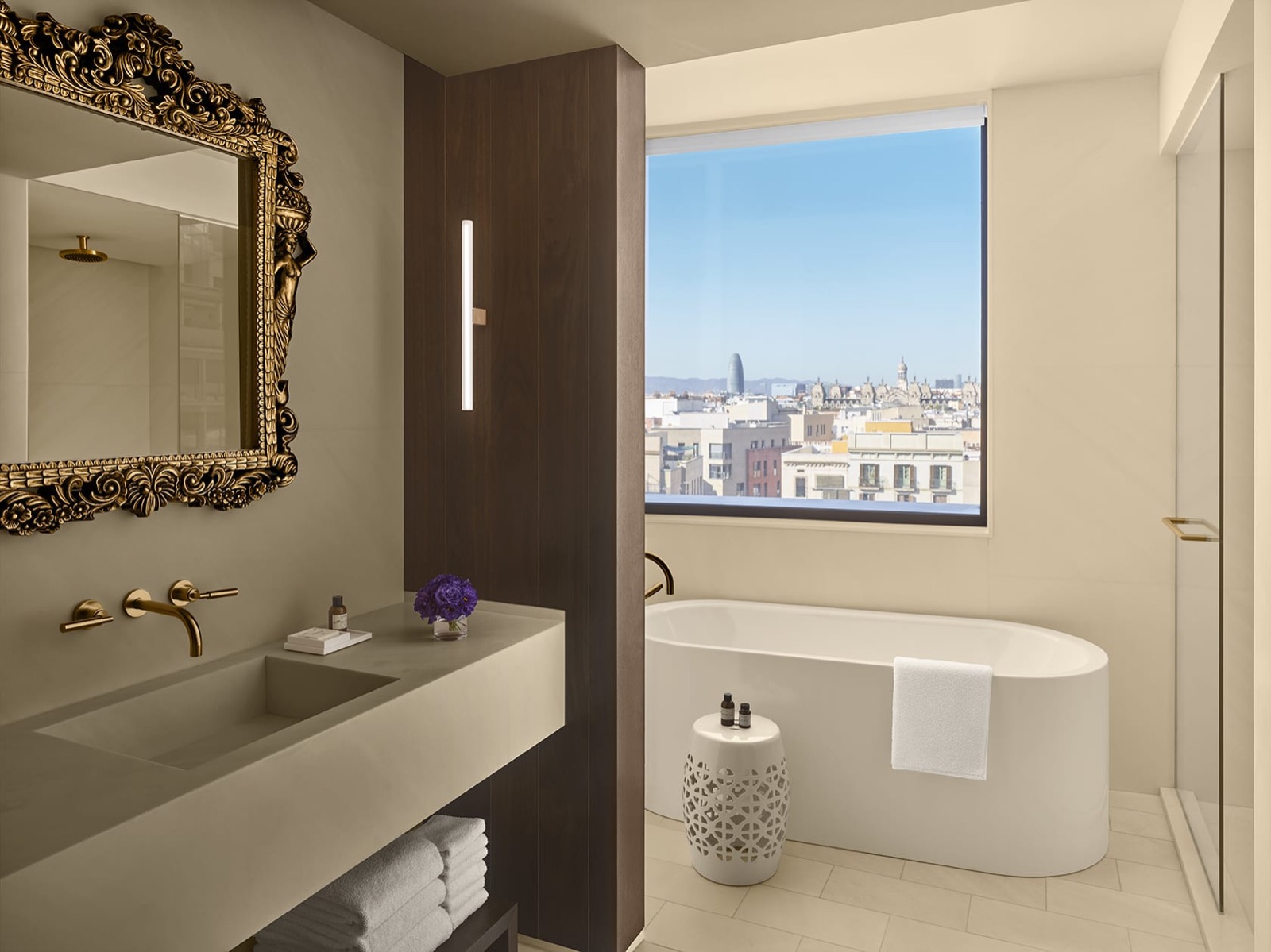 Bathroom with a freestanding tub, an ornate mirror and a skyline view