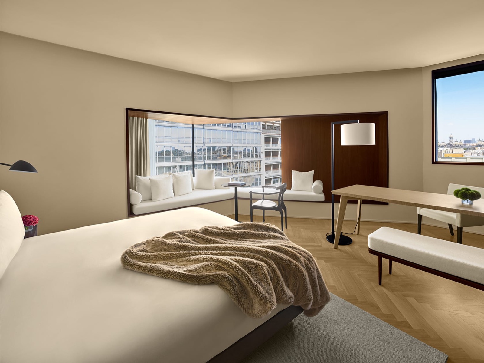 Loft Suite bedroom with corner window seating and a city view
