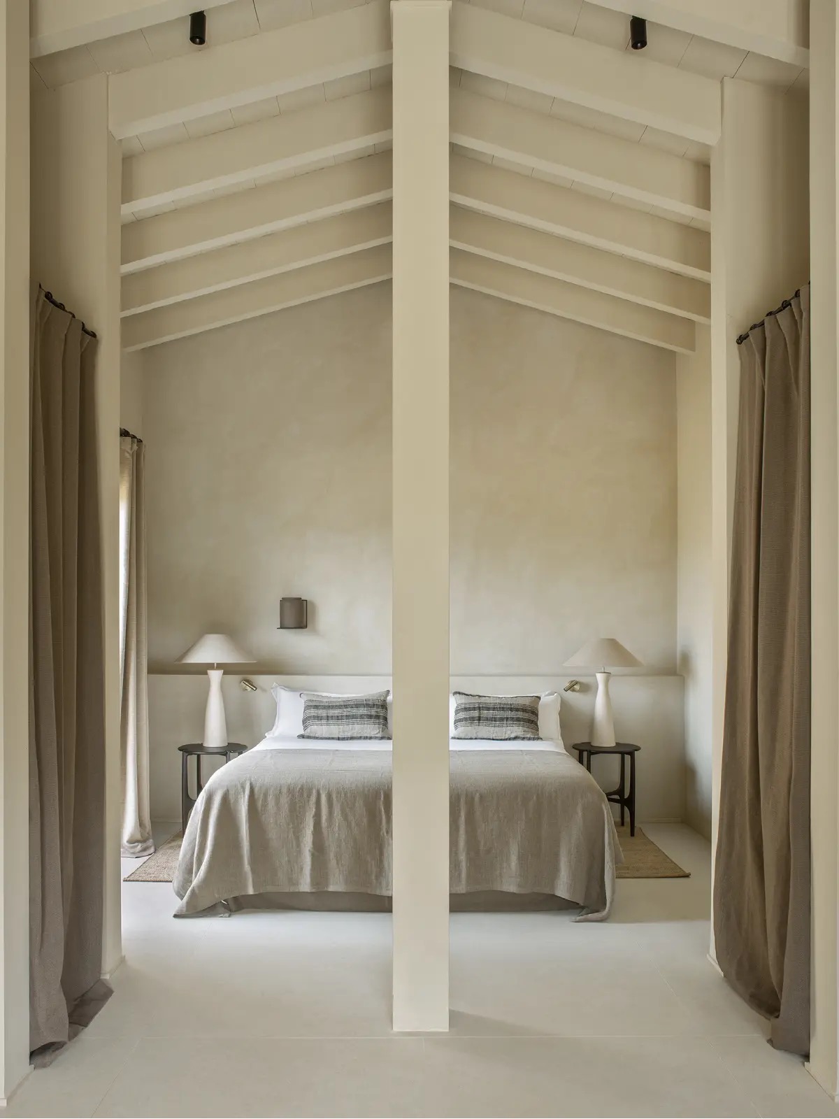 Suite bedroom at The Lodge Mallorca with vaulted beamed ceiling