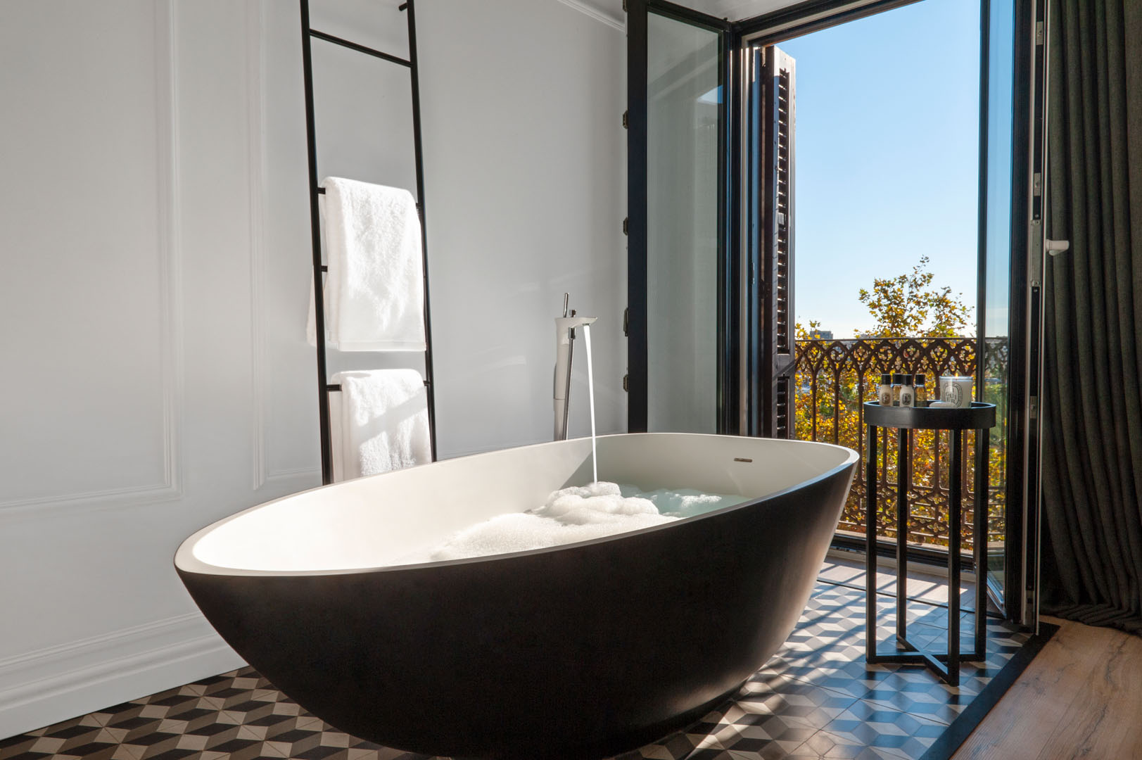 Junior suite bathroom with a freestanding tub opening onto a balcony
