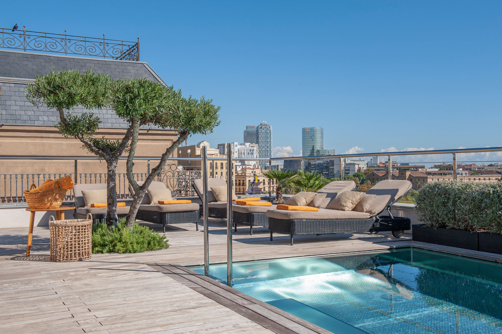 The Serras rooftop pool and sun loungers with a city skyline view