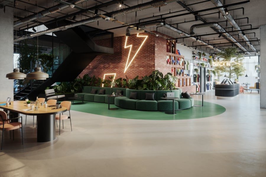 Industrial-style lobby at The Social Hub Barcelona Poblenou with a neon lightning-bolt sign on exposed brick, a curved green sofa, and an open-plan check-in desk