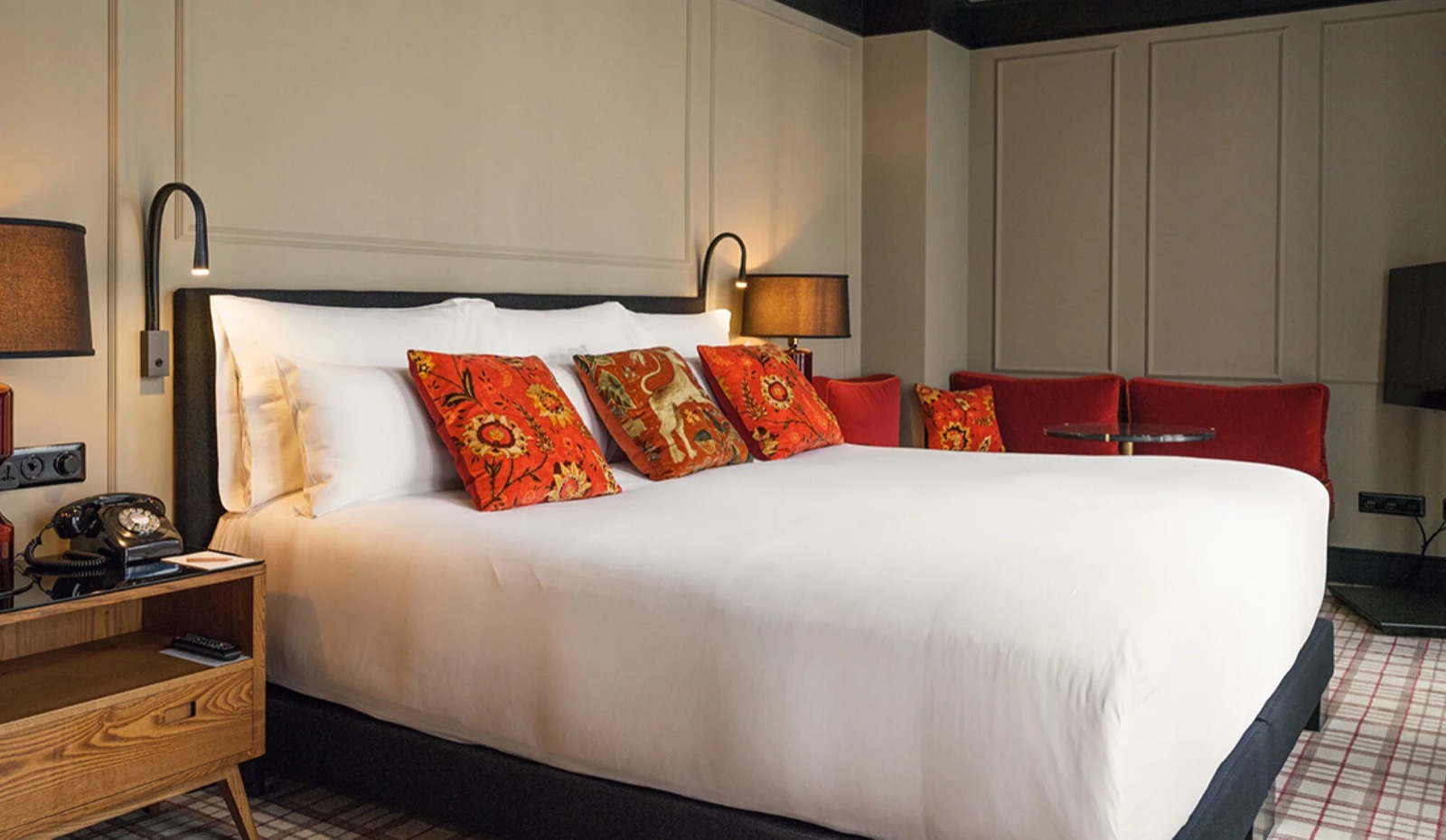 Guest room with red patterned cushions and a vintage rotary phone on the nightstand