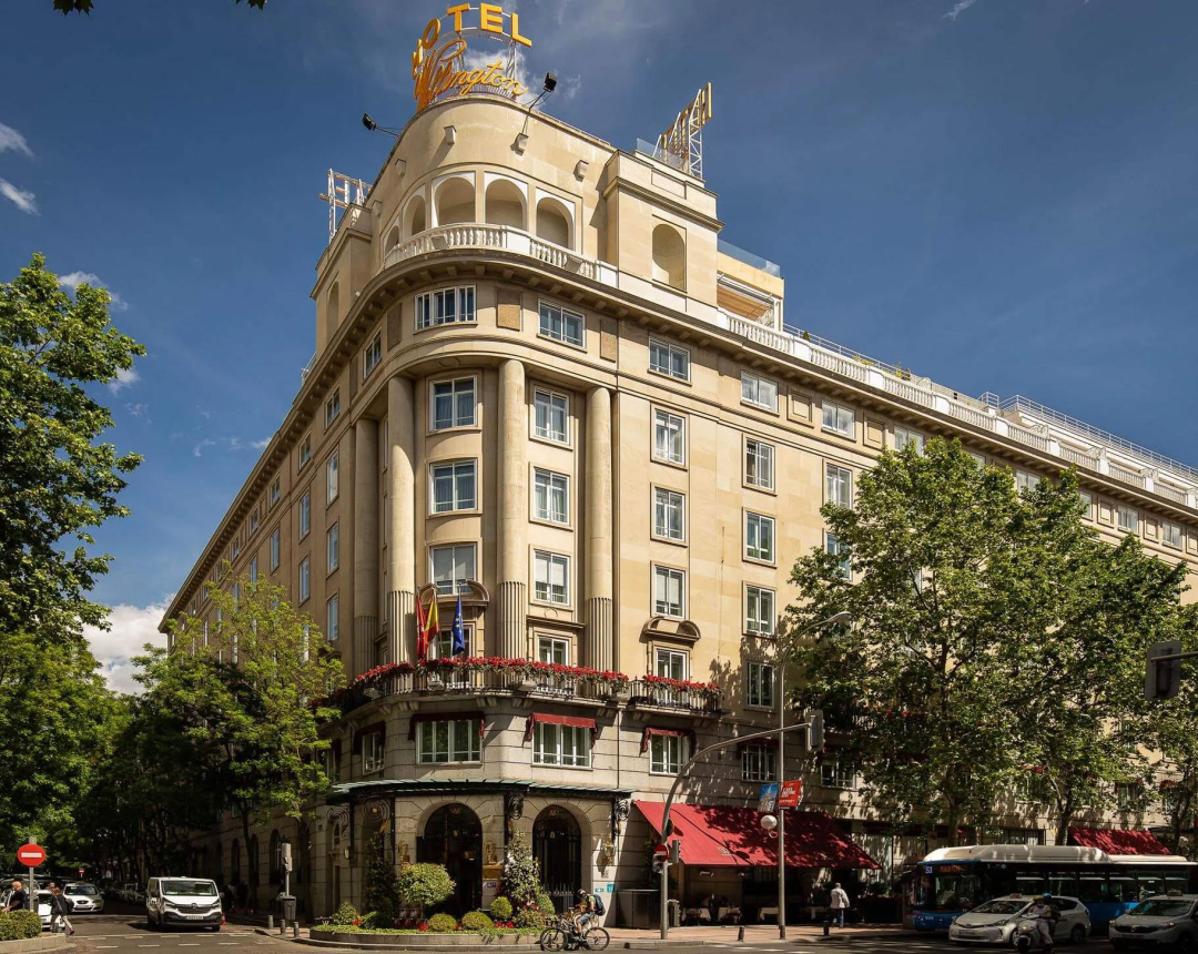 The Wellington's stone corner facade on Calle Velázquez, with red awnings and flower boxes along the first floor.