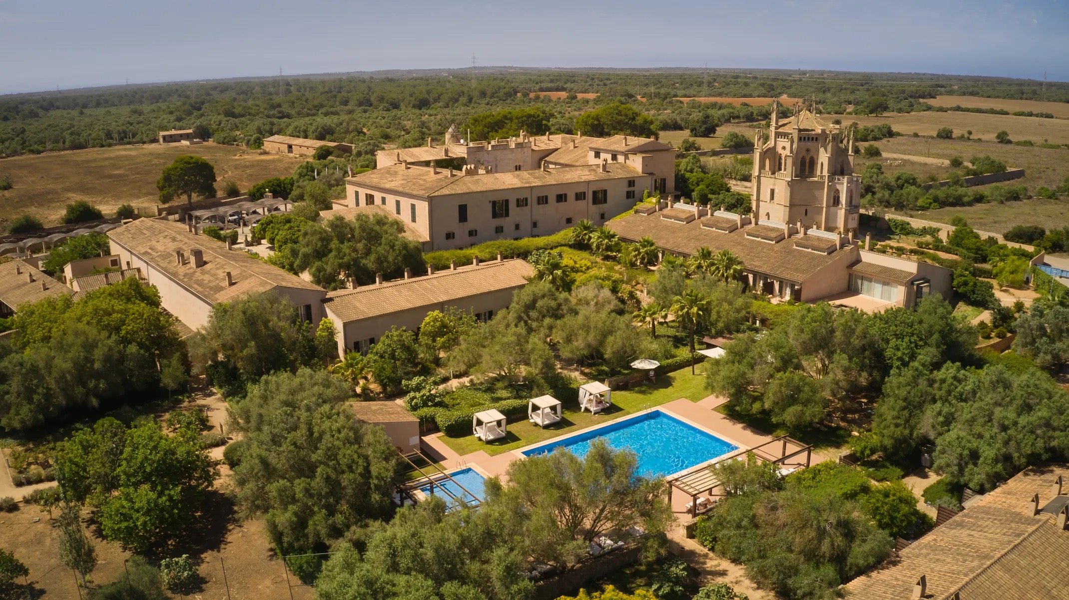 Aerial view of the Sa Torre finca grounds, showing the main house, the neo-Gothic chapel, gardens, and the outdoor pool