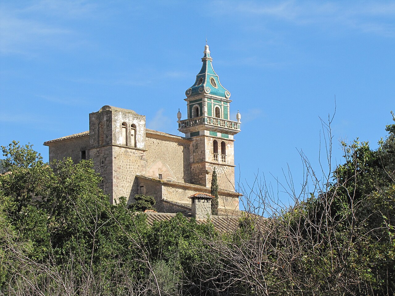 Green-tiled bell tower and facade of the Cartoixa (Carthusian monastery), Valldemossa, Mallorca, Spain