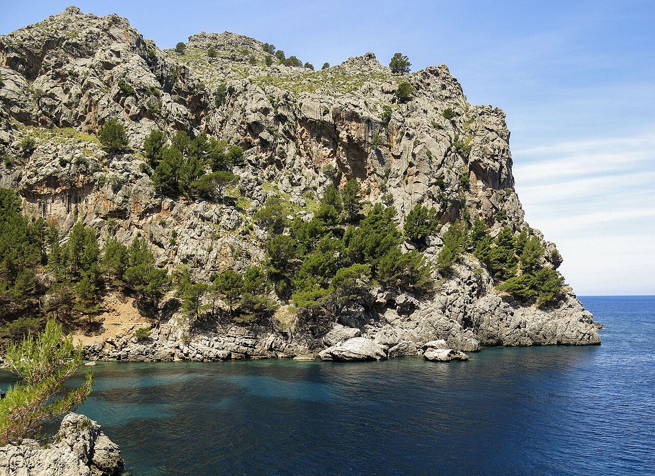 Rugged limestone cliffs meeting turquoise water near Sa Calobra, Escorca, Mallorca, Spain