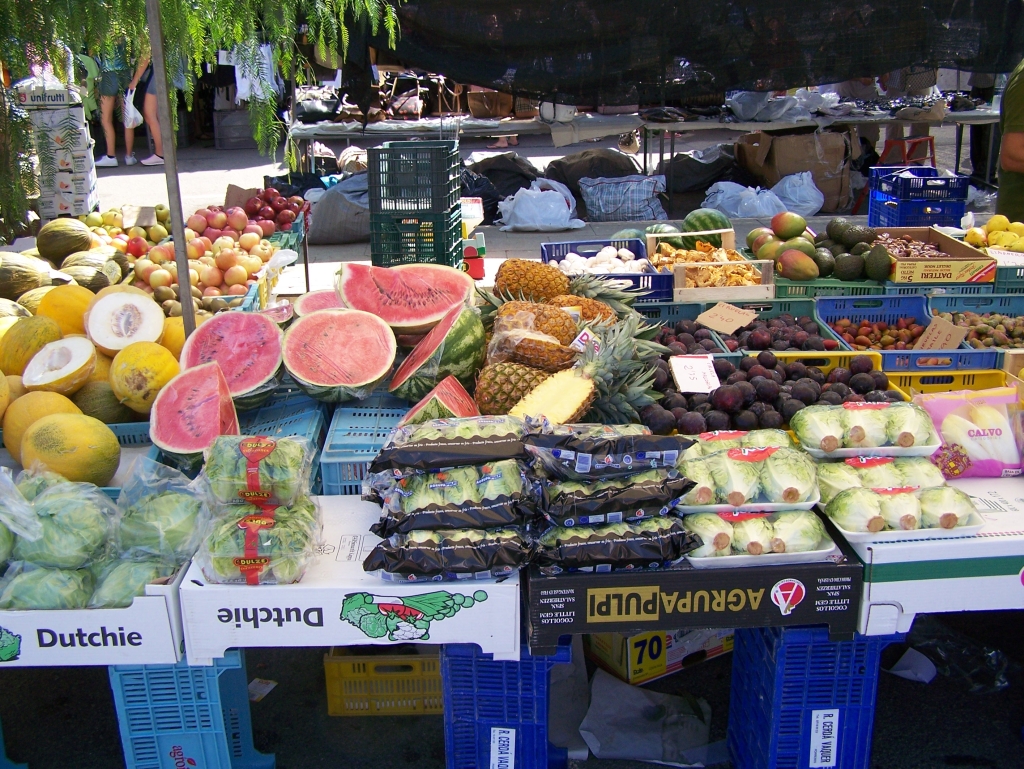A fruit stall piled with melons, watermelon and pineapple at the Pollença market