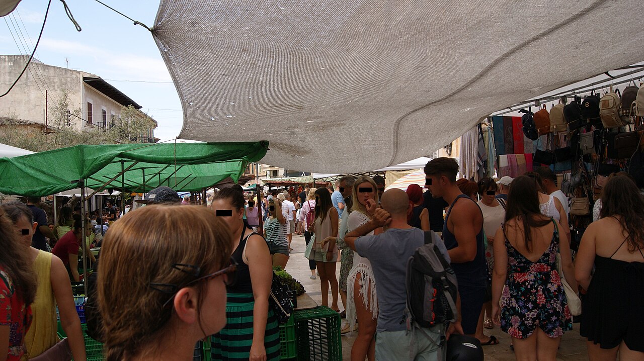 Stalls and shoppers under shade sails at the Santanyí weekly market
