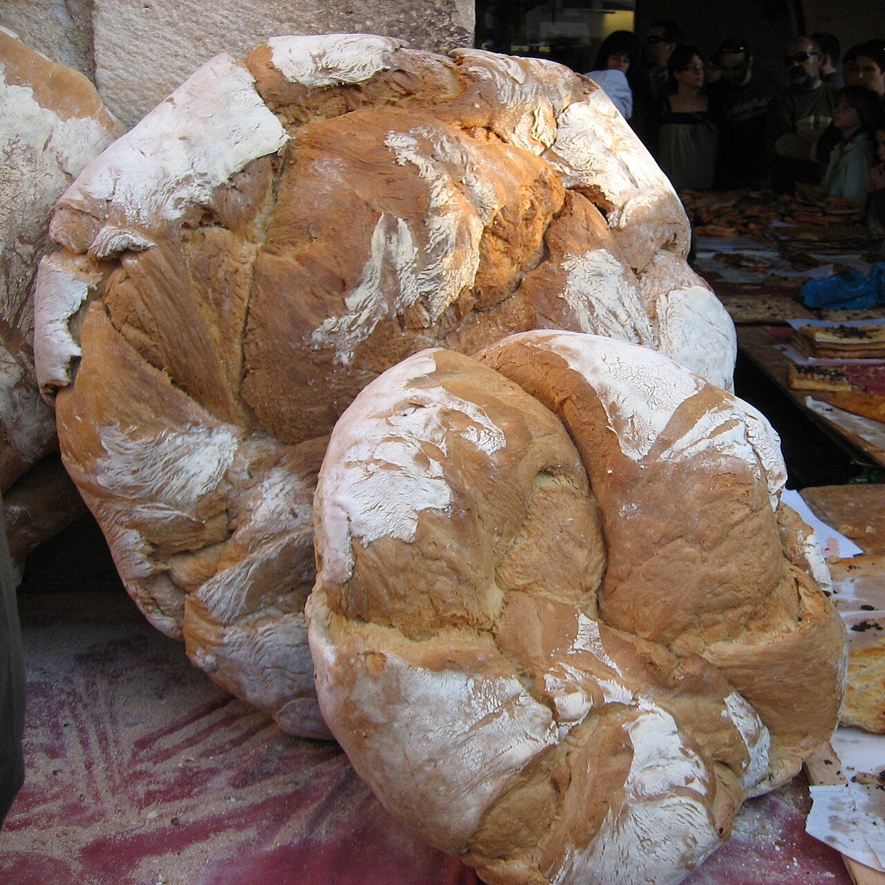 Large round loaves of Catalan pa de pagès at a market stall (illustrative, not one of the named bakeries)