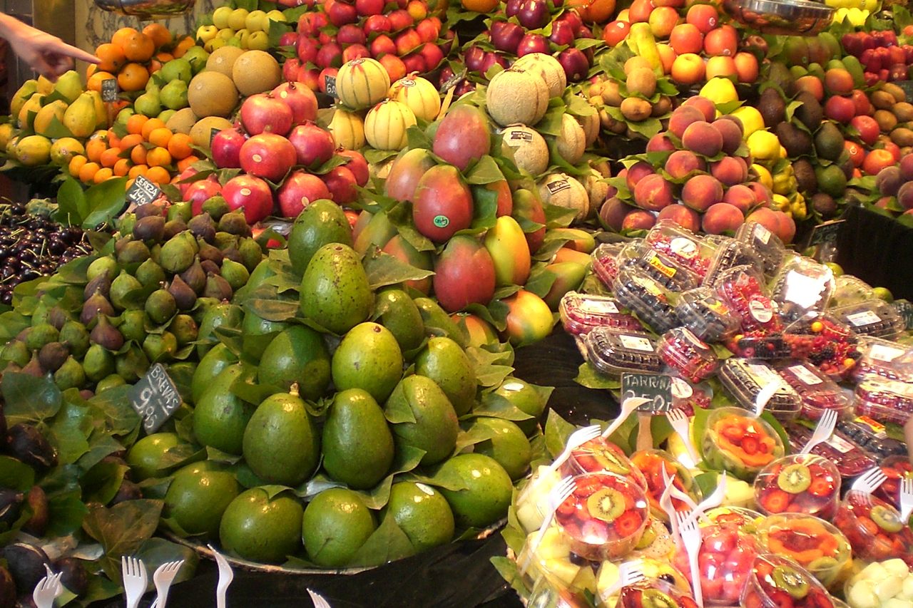 A fruit stall piled with produce inside La Boqueria market