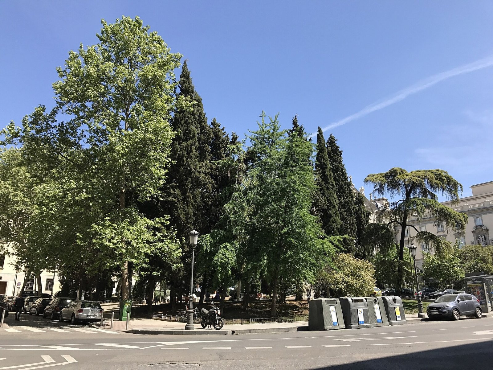 Trees, benches and buildings around Plaza de las Salesas in Madrid on a sunny day.