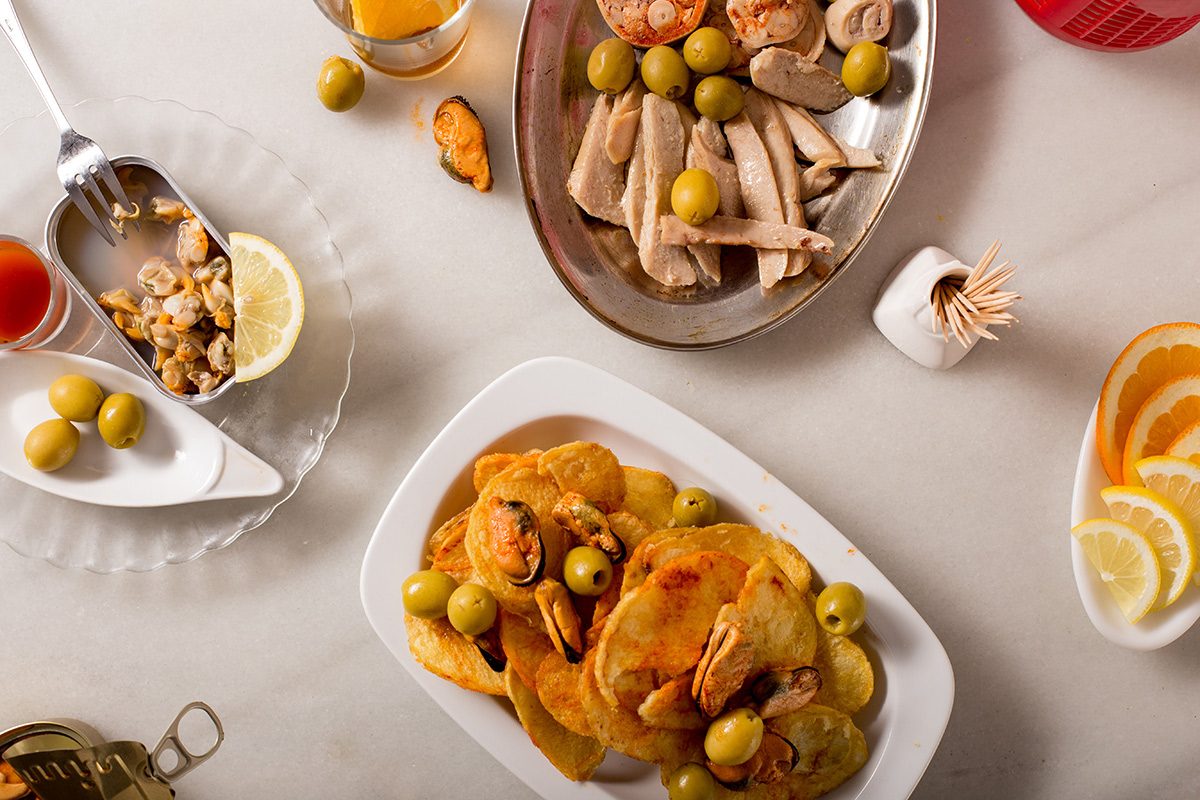 Conservas, olives, mussels and crisps on a marble table, from Barcelona vermouth brand Morro Fi.