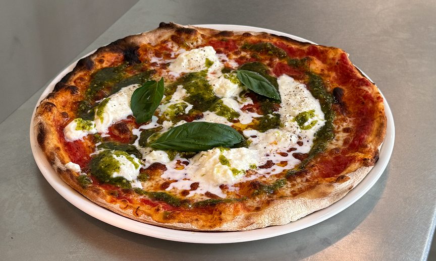 A pizza topped with fresh cheese, pesto and basil at PizzaBar Barcelona.