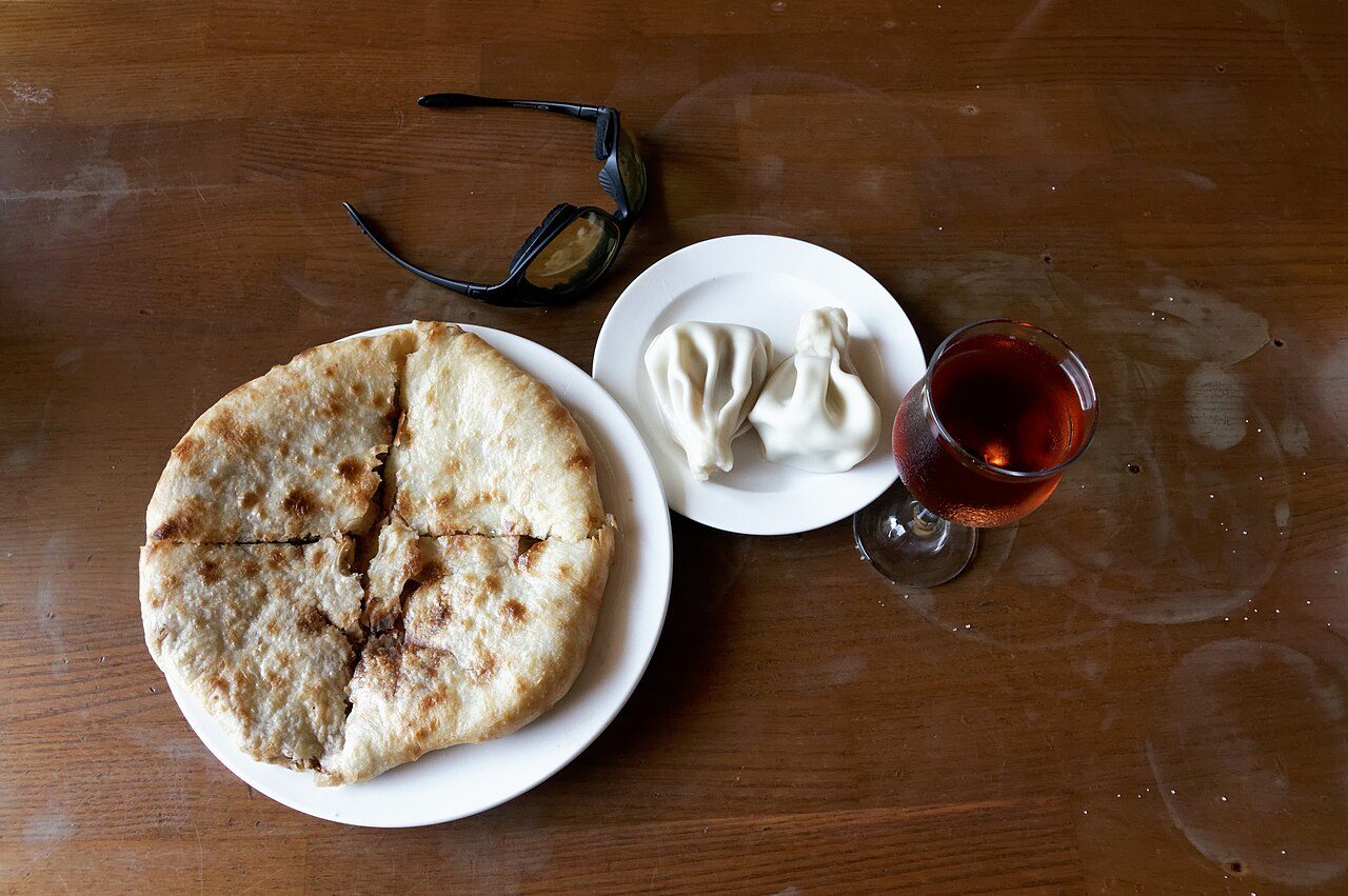 Georgian khachapuri and khinkali with a glass of wine, photographed in Tbilisi (illustrative, not the Barcelona restaurant)
