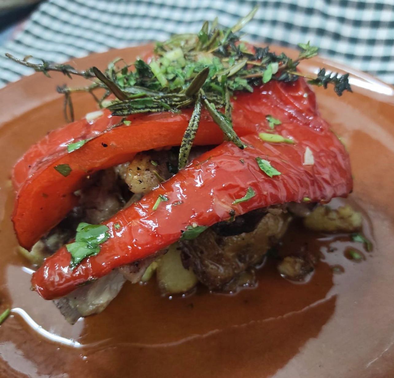 Lamb ribs topped with roasted red pepper and herbs