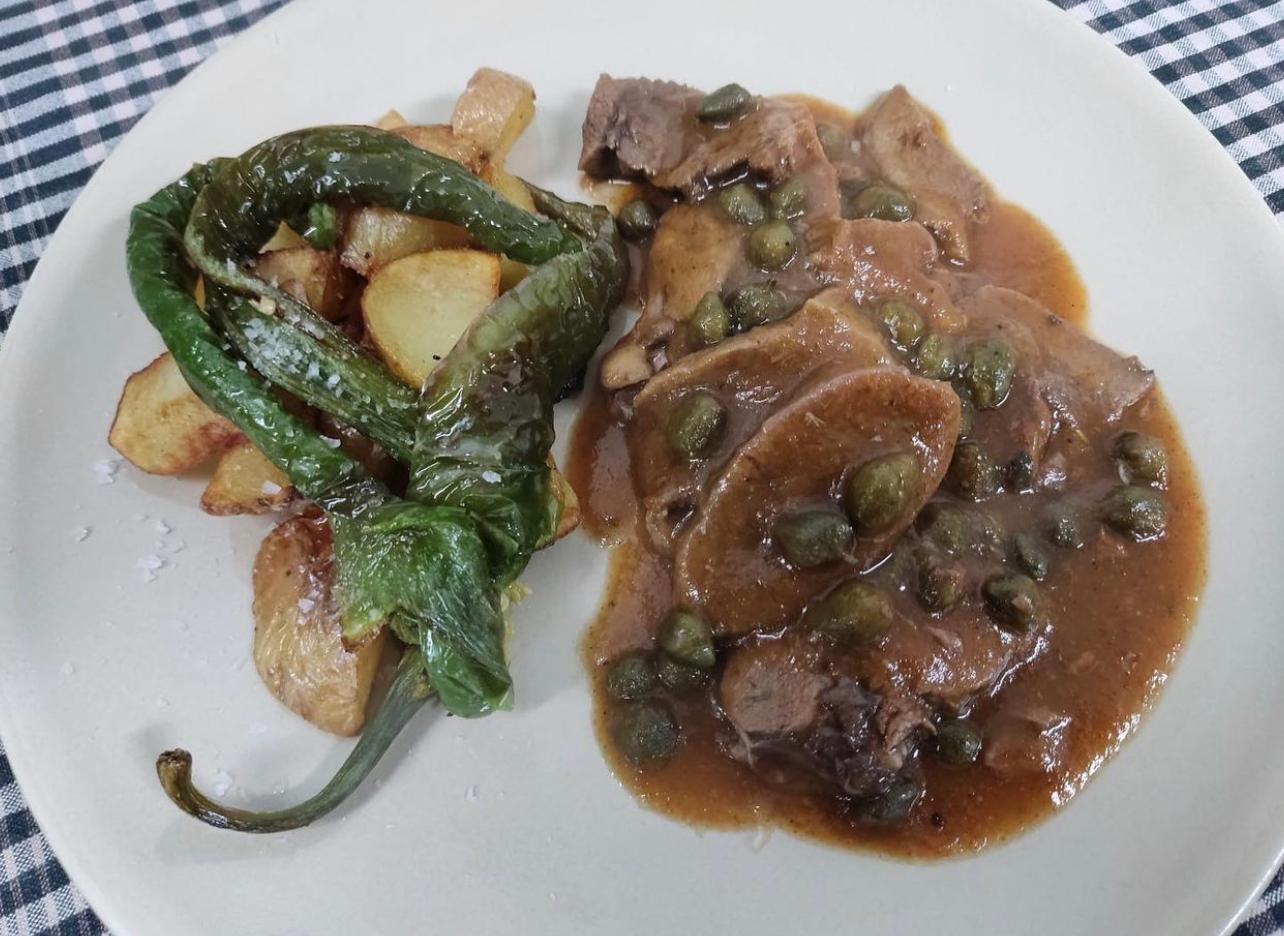 Sliced tongue in caper sauce with fried potatoes and peppers
