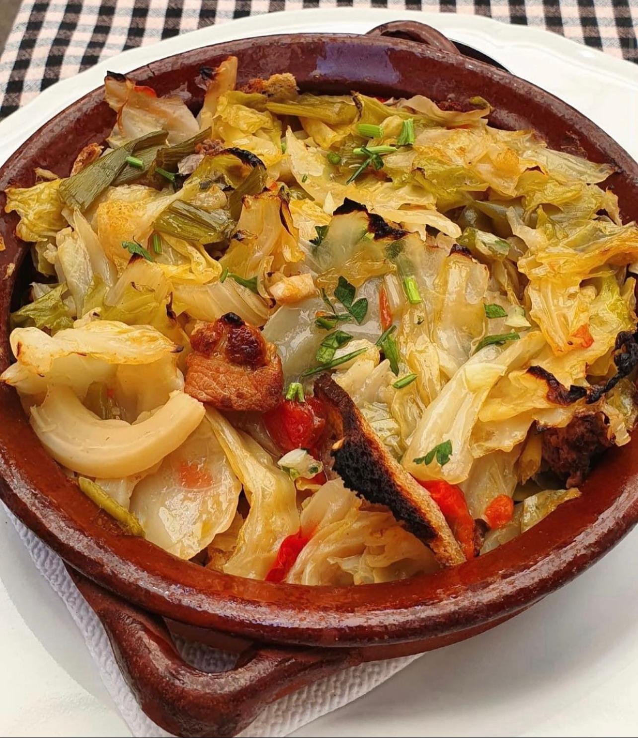 Clay bowl of sopes mallorquines, a baked cabbage and bread dish