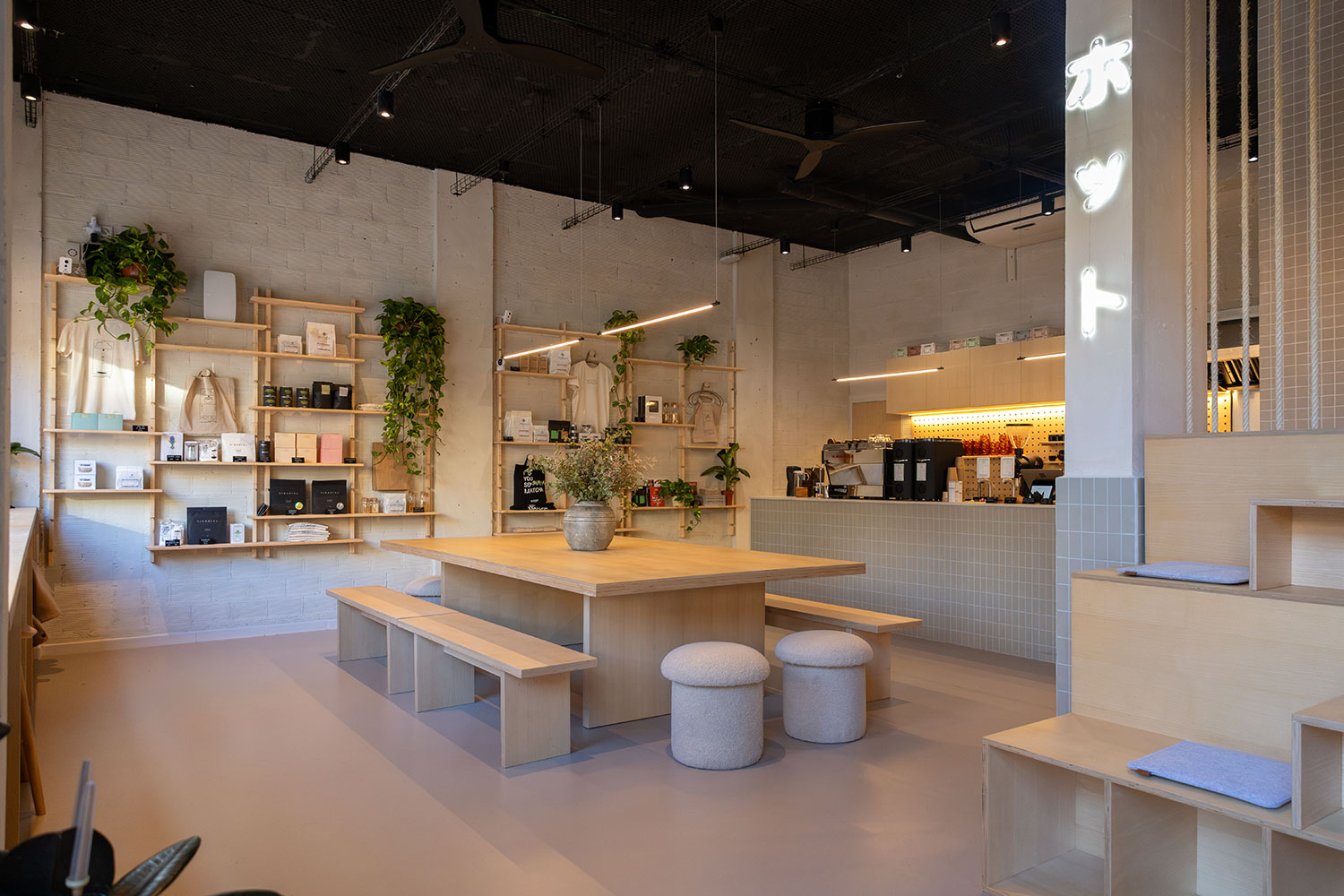 Minimalist interior with communal wood table and espresso bar