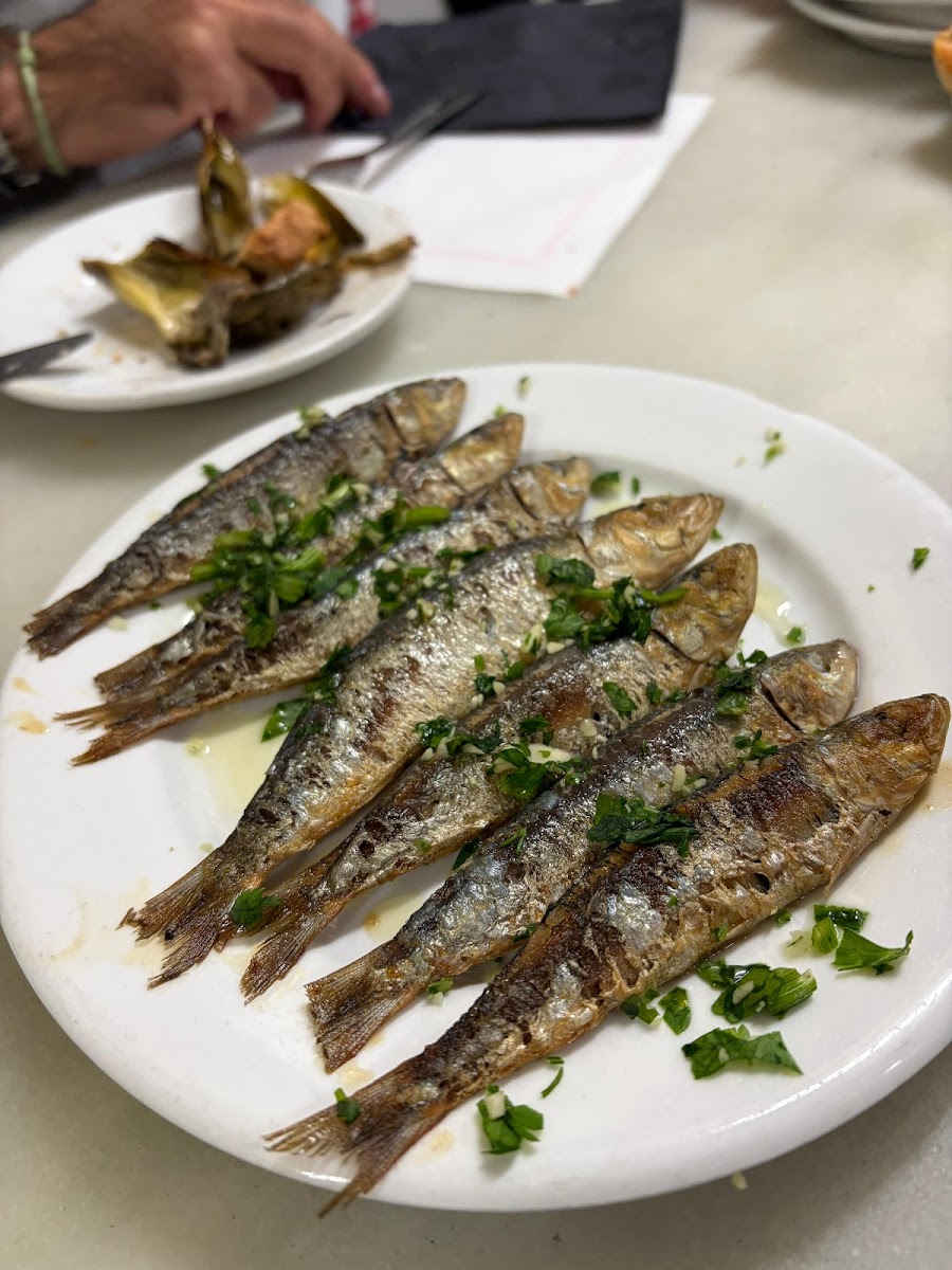 Plate of grilled sardines with parsley at La Cova Fumada