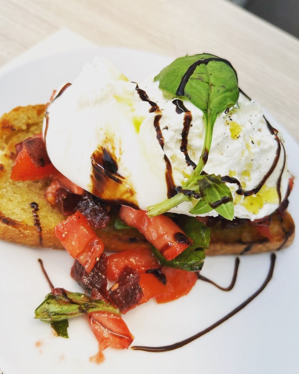 Burrata and tomato bruschetta drizzled with balsamic glaze
