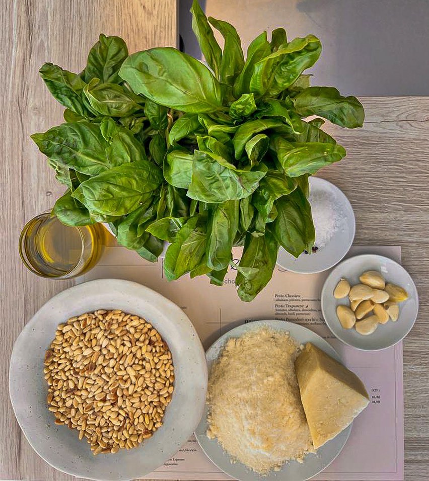 Fresh basil, pine nuts, garlic and parmesan laid out for pesto