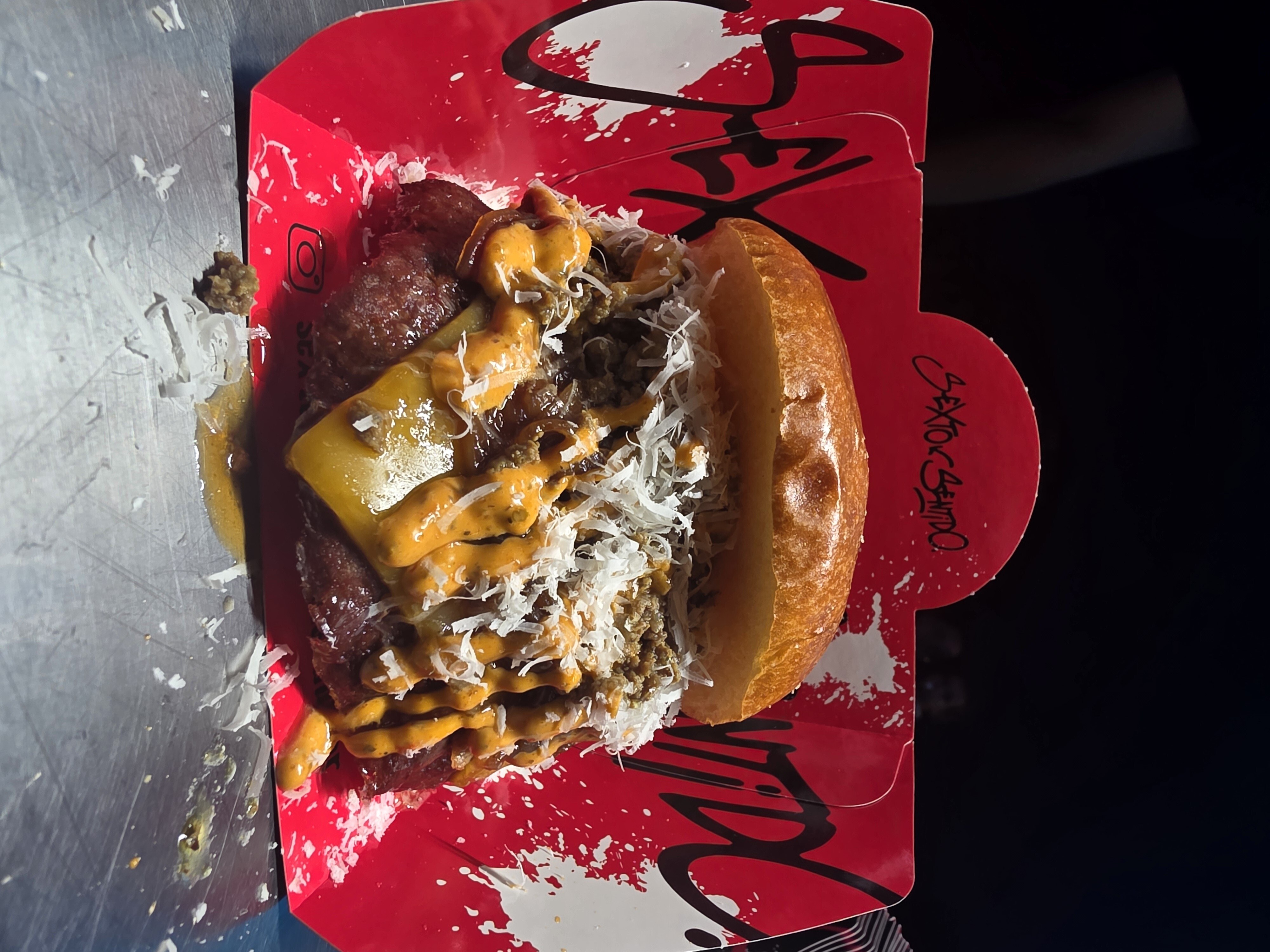 A smash burger served on a tray at Sexto Sentido